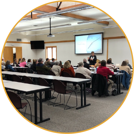 adults sitting at desks looking at PowerPoint