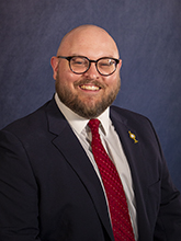 bald man in suit headshot 