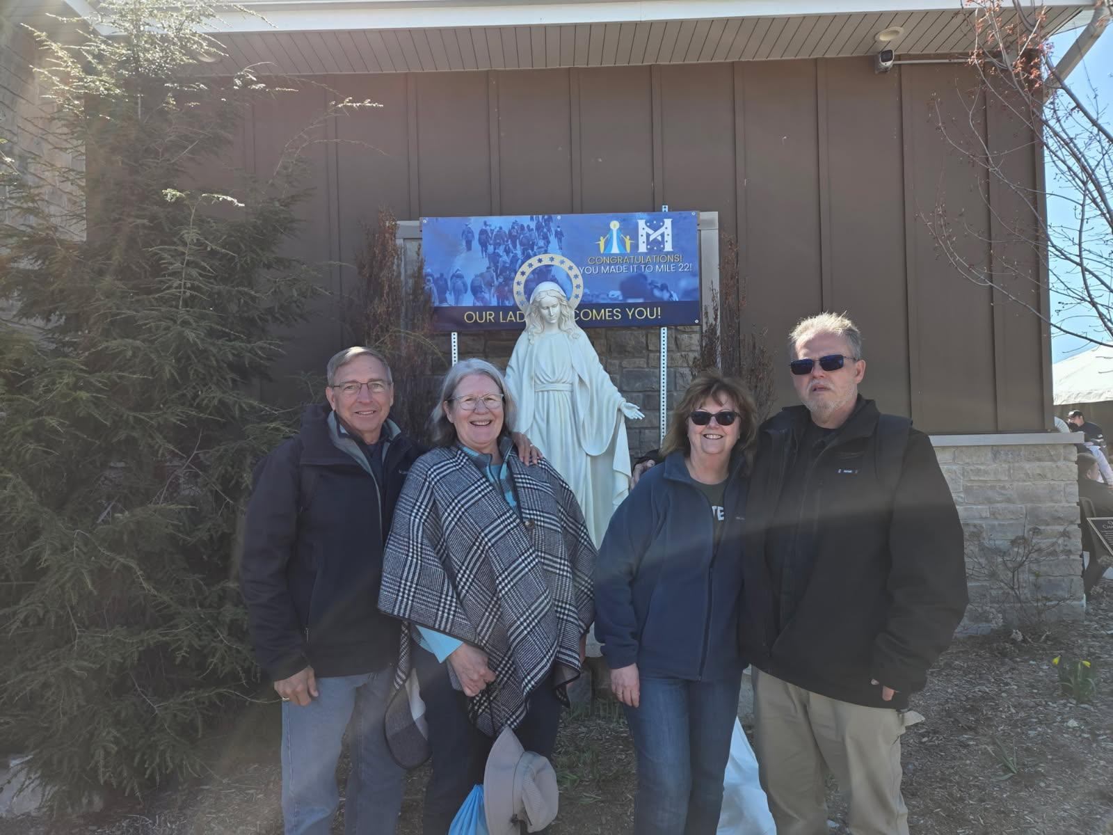 2 straight married couples posing in front of Mary Statue