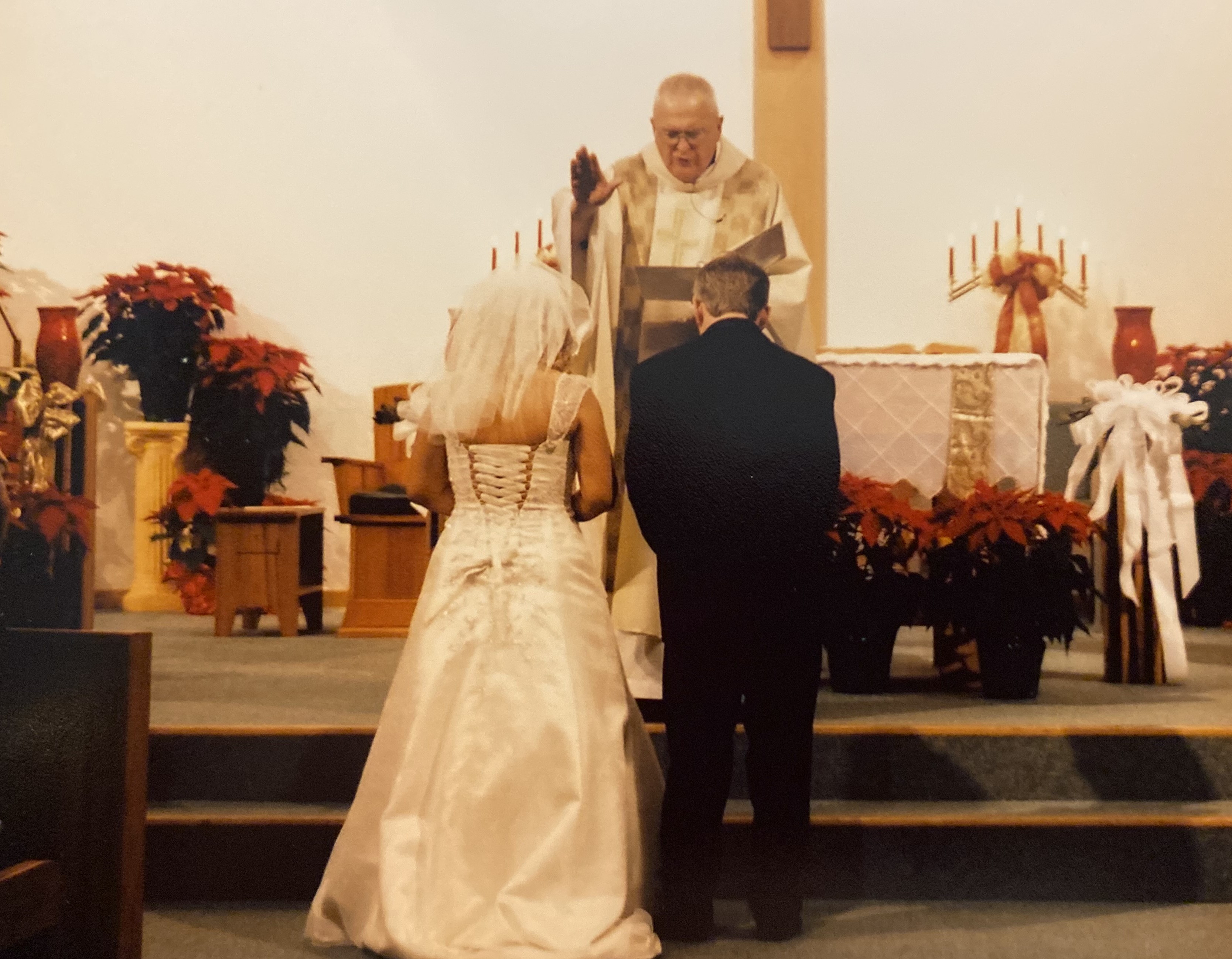 Sara Terry Wilk at their wedding being blessed by priest