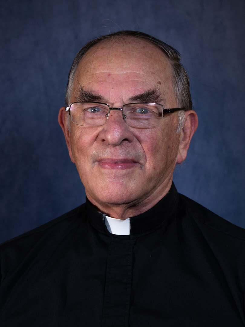 older priest with bushy eyebrows and glasses