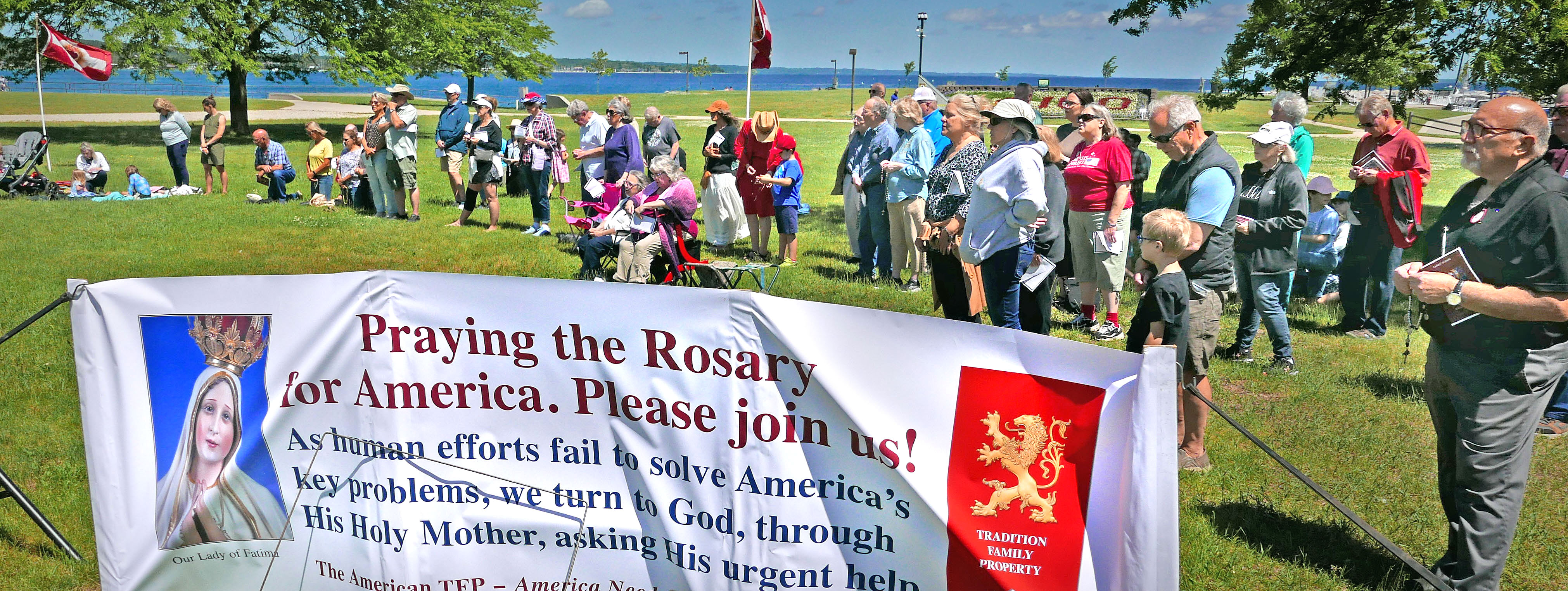 people in a park praying the Rosary
