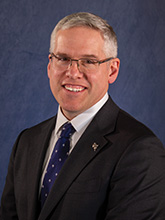 man with glasses in a suit and tie