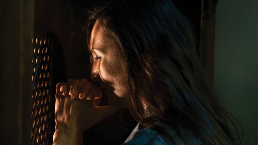 woman praying in confession box