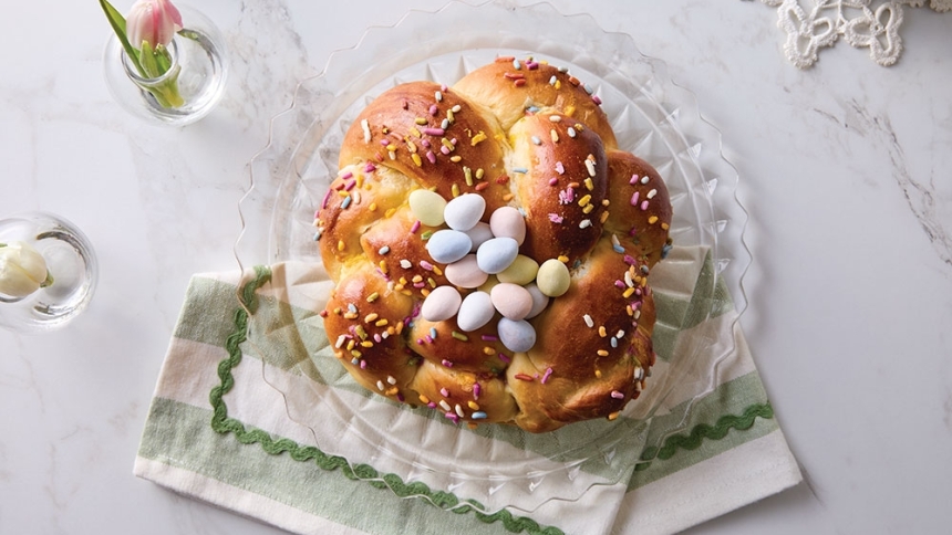 Italian Easter bread with sprinkles and pastel chocolate eggs on a decorative plate