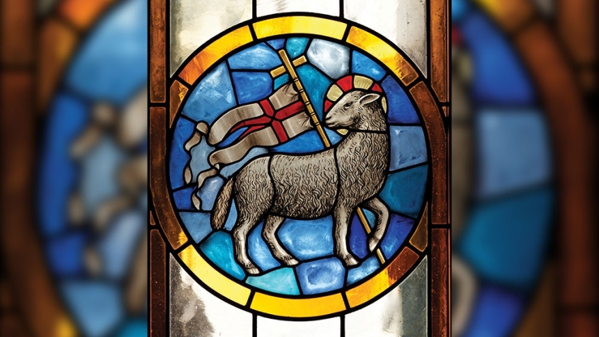 stained glass depicted a lamb and a cross with a banner on it 