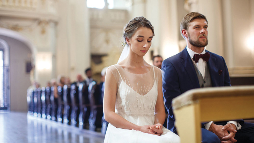 bride and groom sitting in pew