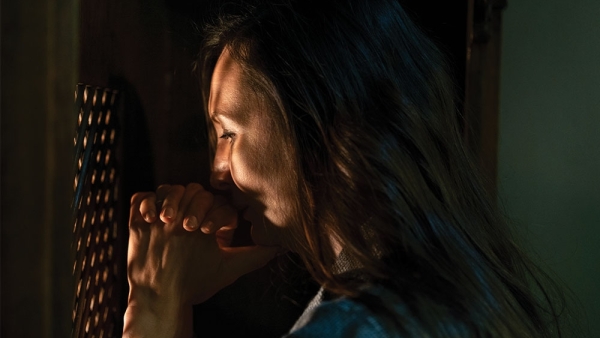 woman praying in confession box